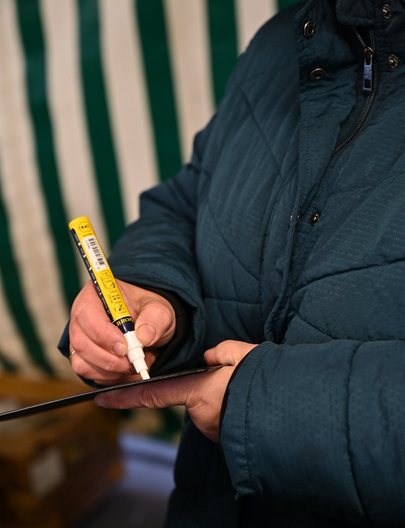 Main écrivant le prix à la craie sur une ardoise de marché